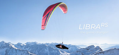 roter RC Paraglider am Himmel über weiße Alpenlandschaft